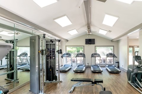 a gym with treadmills and other exercise equipment and windows